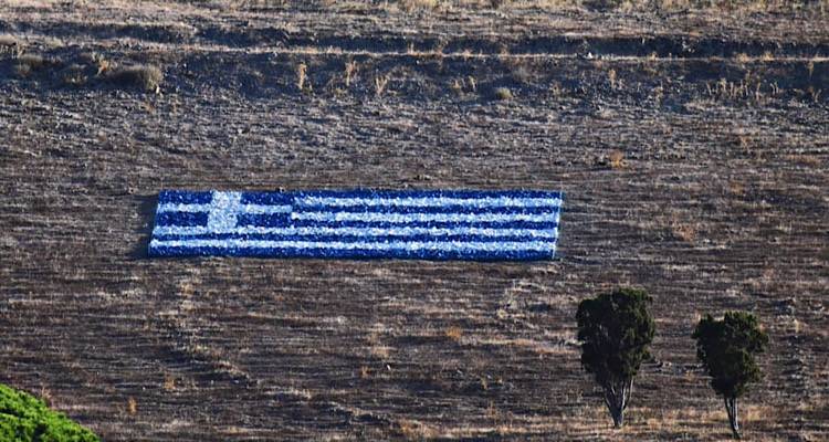 Λήμνος: Μια τεράστια γαλανόλευκη «κυματίζει» από σήμερα στο ύψωμα των Τσιμανδρίων (Photos)